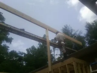 Carpenter setting a ridge beam over a new addition frame — Ice Dam Removal by Roofing Brothers in Orchard Park