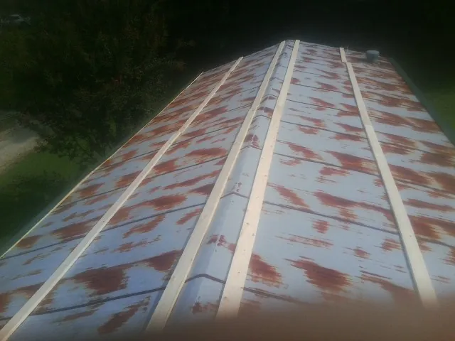 Rusted metal roof panels with new wood purlins before replacement — Storm Damage Roof Repair in Orchard Park by Roofing Brothers